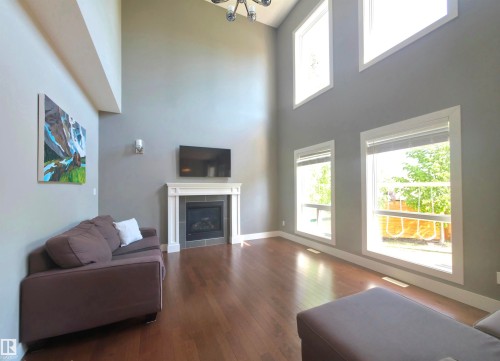 Spacious living area featuring high ceilings, wood-finish flooring, and multiple windows - 1 Hemlock Close, Fort Saskatchewan, AB 