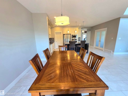 Spacious dining area featuring tile flooring, a wood-finish dining table, and a contemporary drum pendant light fixture - 1 Hemlock Close, Fort Saskatchewan, AB 