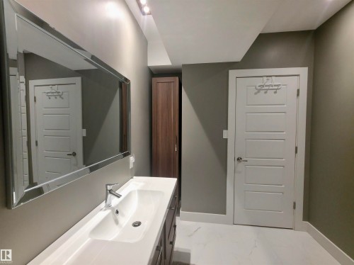 Bathroom vanity with a rectangular undermount sink, chrome faucet, and a large mirrored cabinet - 1 Hemlock Close, Fort Saskatchewan, AB 