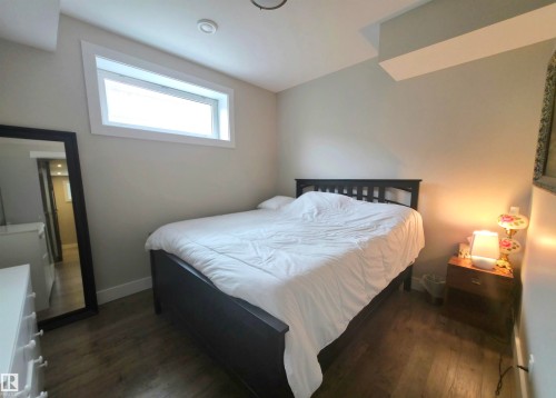 Bedroom featuring a horizontal window, wood-finish flooring, recessed lighting, and neutral wall tones - 1 Hemlock Close, Fort Saskatchewan, AB 