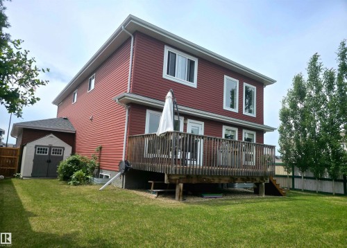 Two-story residence featuring red horizontal siding, white trim, and multiple window styles - 1 Hemlock Close, Fort Saskatchewan, AB 