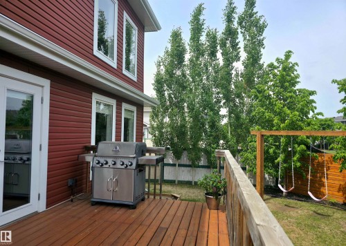 Expansive wooden deck with wooden railing and glass-paneled French door access - 1 Hemlock Close, Fort Saskatchewan, AB 
