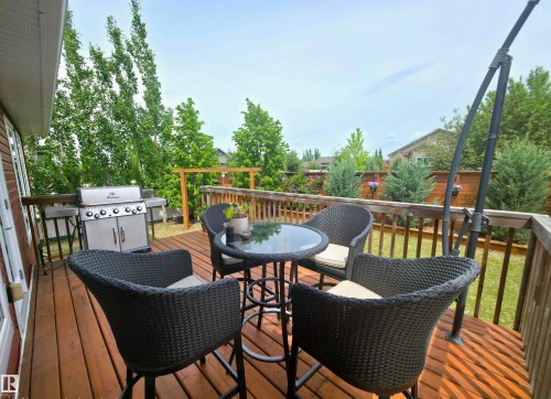 Expansive wood deck with a full-height wood privacy fence, surrounded by mature trees - 1 Hemlock Close, Fort Saskatchewan, AB 