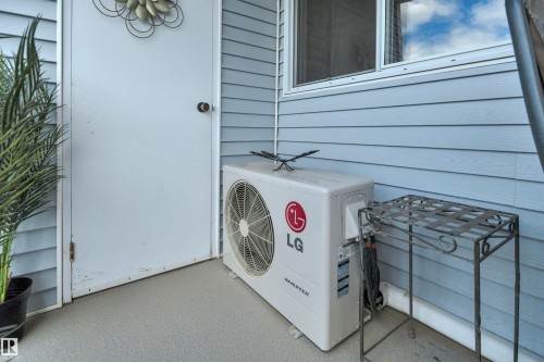 Light blue horizontal siding exterior with a white door and white window trim - 305 5212 48 Avenue, Wetaskiwin, AB 