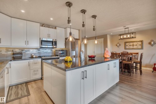 White shaker cabinetry with dark stone countertops and an integrated kitchen island - 305 5212 48 Avenue, Wetaskiwin, AB 