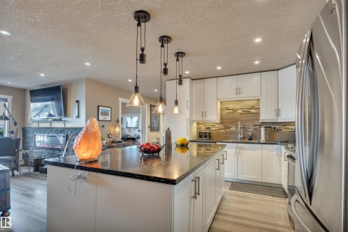 Modern kitchen featuring white cabinetry, dark countertops, and stainless steel appliances - 305 5212 48 Avenue, Wetaskiwin, AB 