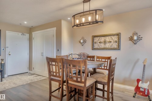 Dining area featuring wood-finish flooring, recessed lighting, and a contemporary oval chandelier with exposed bulbs - 305 5212 48 Avenue, Wetaskiwin, AB 
