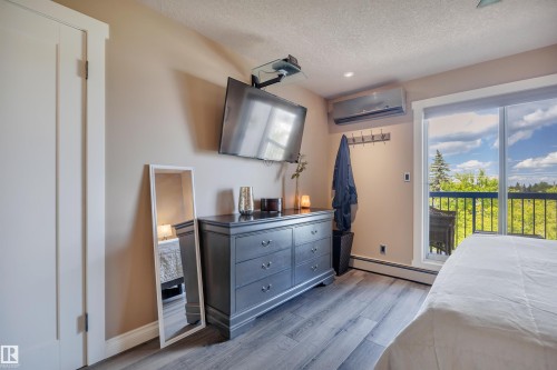Sliding glass doors opening to an outdoor balcony with black metal railings - 305 5212 48 Avenue, Wetaskiwin, AB 