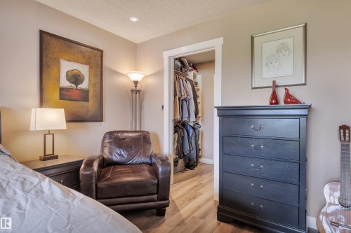Walk-in closet with custom shelving and wood-finish flooring - 305 5212 48 Avenue, Wetaskiwin, AB 