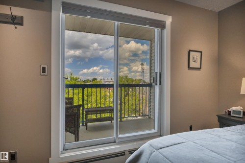Sliding glass door leading to a private balcony with black metal railing - 305 5212 48 Avenue, Wetaskiwin, AB 