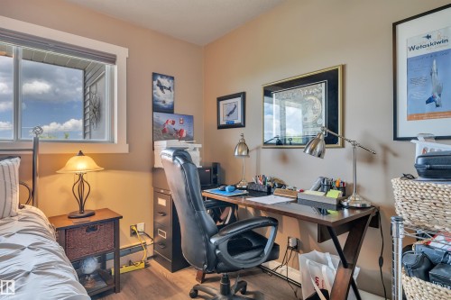 Room featuring neutral-toned walls, wood-finish flooring, a double-paned window, and white trim - 305 5212 48 Avenue, Wetaskiwin, AB 