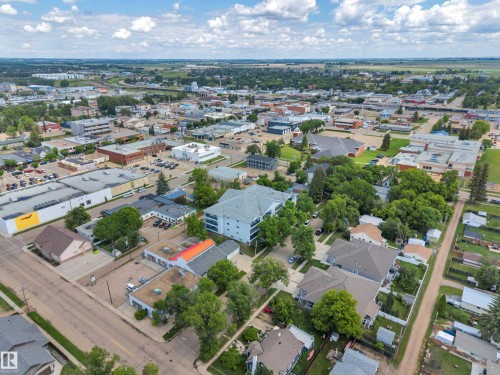 Residential and commercial properties set within a developed area featuring mature trees and established infrastructure - 305 5212 48 Avenue, Wetaskiwin, AB 