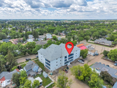 Four-story apartment building with a light-colored exterior and multiple balconies - 305 5212 48 Avenue, Wetaskiwin, AB 