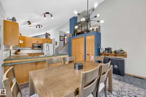 Dining area featuring a modern sputnik chandelier, wood-finish flooring, and light gray walls - 1 Primrose Boulevard, Sherwood Park, AB 