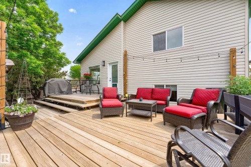 Multi-level wood deck featuring a tiered design, direct access to the interior, and string lighting - 1 Primrose Boulevard, Sherwood Park, AB 