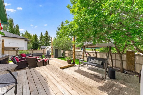 Spacious backyard featuring a multi-level wood deck, mature trees, a storage shed, and privacy fencing - 1 Primrose Boulevard, Sherwood Park, AB 