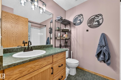 Bathroom vanity featuring a white oval sink with a matte black faucet, set into a green countertop - 1 Primrose Boulevard, Sherwood Park, AB 