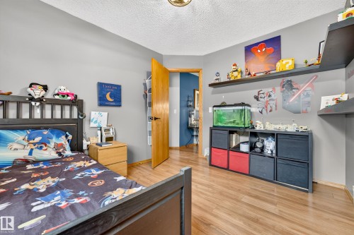Bedroom featuring wood-finish flooring, light gray walls, and a white textured ceiling - 1 Primrose Boulevard, Sherwood Park, AB 