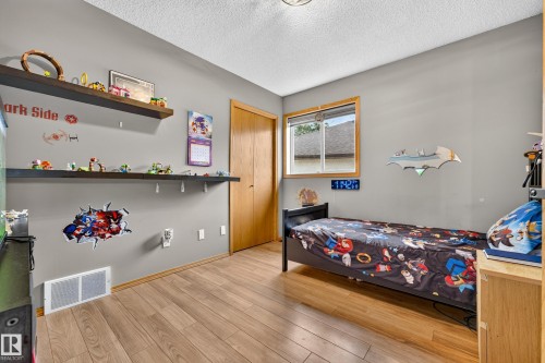 Room featuring wood-finish flooring, a double-pane window with wood trim, and a recessed ceiling light fixture - 1 Primrose Boulevard, Sherwood Park, AB 