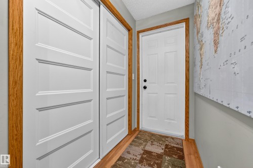 Wood-finish flooring with a white paneled door featuring black hardware - 1 Primrose Boulevard, Sherwood Park, AB 
