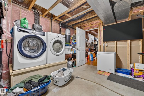Dedicated laundry area featuring exposed wood framing, concrete flooring, and an adjacent storage space - 1 Primrose Boulevard, Sherwood Park, AB 