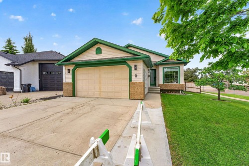 Ranch-style residence featuring a two-car garage, concrete driveway, and a manicured front lawn - 1 Primrose Boulevard, Sherwood Park, AB 
