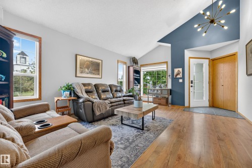 Living area featuring vaulted ceilings, wood-finish flooring, and multiple window exposures - 1 Primrose Boulevard, Sherwood Park, AB 