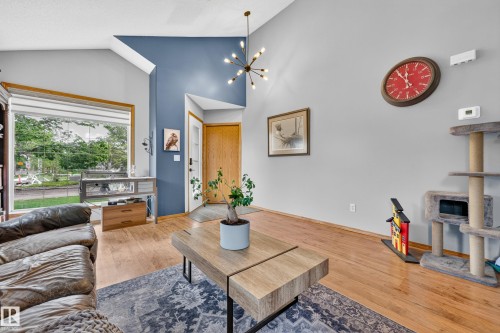 Open living space featuring a vaulted ceiling and a contemporary chandelier - 1 Primrose Boulevard, Sherwood Park, AB 
