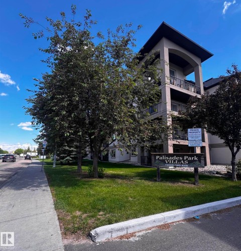 Multi-story building featuring stucco exterior, arched portico, multiple balconies with metal railings, and a prominent entry sign - 330 13111 140 Avenue, Edmonton, AB 