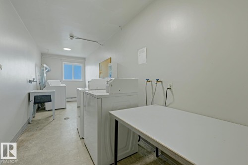 Dedicated laundry area featuring multiple washing machines and dryers - 15 10164 150 Street, Edmonton, AB 