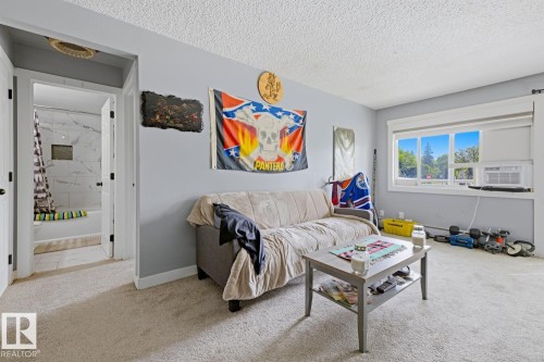 Carpeted room with a window providing exterior views - 15 10164 150 Street, Edmonton, AB 