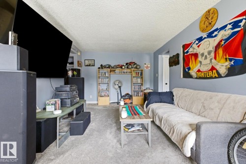 Carpeted room with light blue walls and a textured ceiling - 15 10164 150 Street, Edmonton, AB 