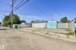 Detached garage with a white overhead door and an additional turquoise roll-up door - 