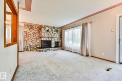 Living area featuring a floor-to-ceiling stone fireplace with a wood mantle and hearth - 