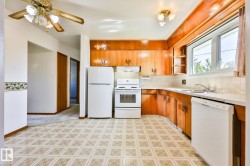 Kitchen featuring wood-finish cabinetry, white appliances, and a window above the sink - 