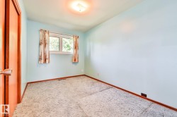 Room featuring light blue walls, gray carpet, and a window with white framing - 