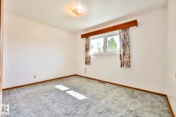 Room featuring light-colored wall paint, grey patterned carpeting, and a window with a wood valance - 
