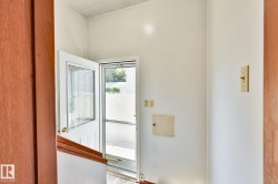 Entryway featuring a white paneled door with decorative glass inserts and a screen door - 