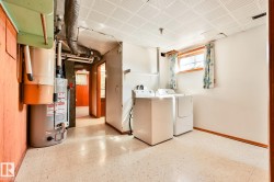 Utility space featuring a water heater, furnace, and exposed ductwork - 