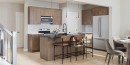 Modern kitchen featuring wood-finish cabinetry, stainless steel appliances, and a central island with bar seating - 47 Chartres Close, St. Albert, AB 