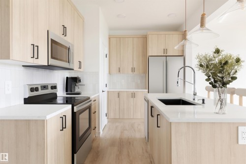 Kitchen featuring light wood-finish cabinetry, white countertops, and stainless steel appliances - 47 Chartres Close, St. Albert, AB 