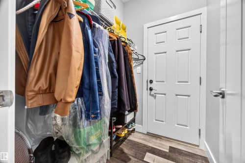 White six-panel interior door with matte black hardware, wood-finish flooring, and light gray wall paint - 1603 158 Street, Edmonton, AB 