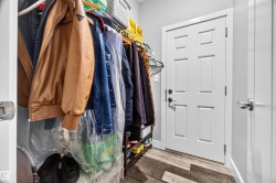 White six-panel interior door with matte black hardware, wood-finish flooring, and light gray wall paint - 