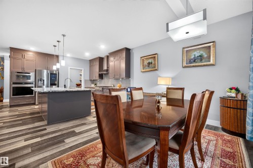 Spacious dining area featuring wood-finish flooring and an overhead rectangular light fixture - 1603 158 Street, Edmonton, AB 