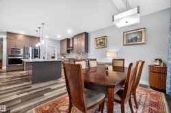 Spacious dining area featuring wood-finish flooring and an overhead rectangular light fixture - 