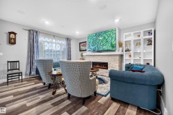 Living space featuring wood-finish flooring, recessed lighting, and a linear electric fireplace with a stacked stone surround - 