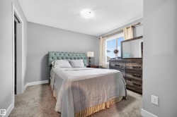 Carpeted bedroom with a window, white trim, and a built-in closet with bifold doors - 