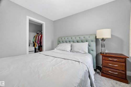 Bedroom featuring light gray wall paint, carpeting, and a built-in closet with white trim - 1603 158 Street, Edmonton, AB 