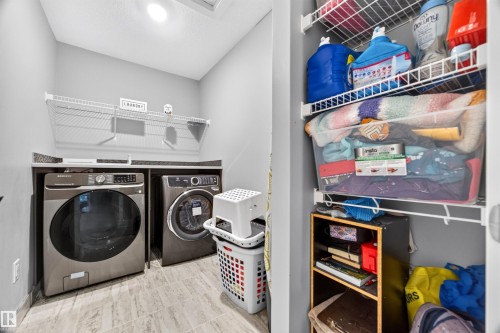 Dedicated laundry area featuring a countertop surface, overhead wire shelving, and wood-look tile flooring - 1603 158 Street, Edmonton, AB 