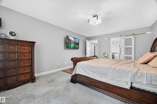Bedroom featuring light gray wall paint, gray carpet flooring, a white trim baseboard, and a flush mount ceiling light - 1603 158 Street, Edmonton, AB 